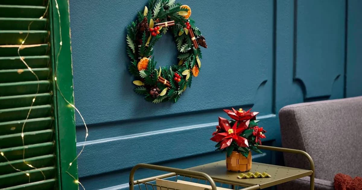 LEGO Wreath 10340 hanging on a teal panelled wall above the Poinsettia 10370 in a basket pot on a brass side table