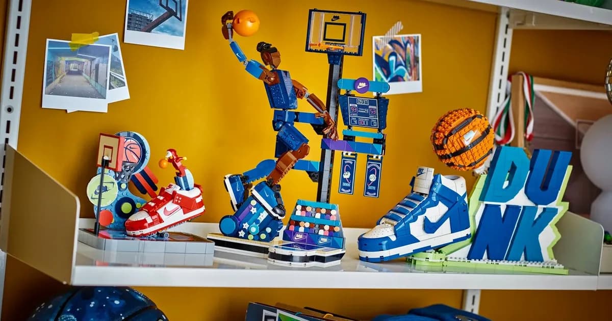 LEGO Nike Slam Dunk player figure, Nike Dunk sneaker with DUNK letters and red Dunk Trickshot set on a yellow shelf with photos and a basketball