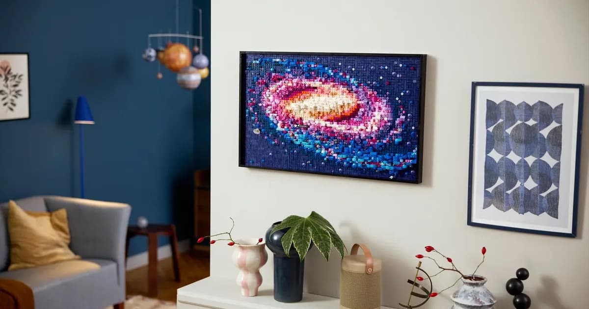 The LEGO Art Milky Way Galaxy mosaic, a pink and blue spiral galaxy in a black frame, on a white wall above a sideboard
