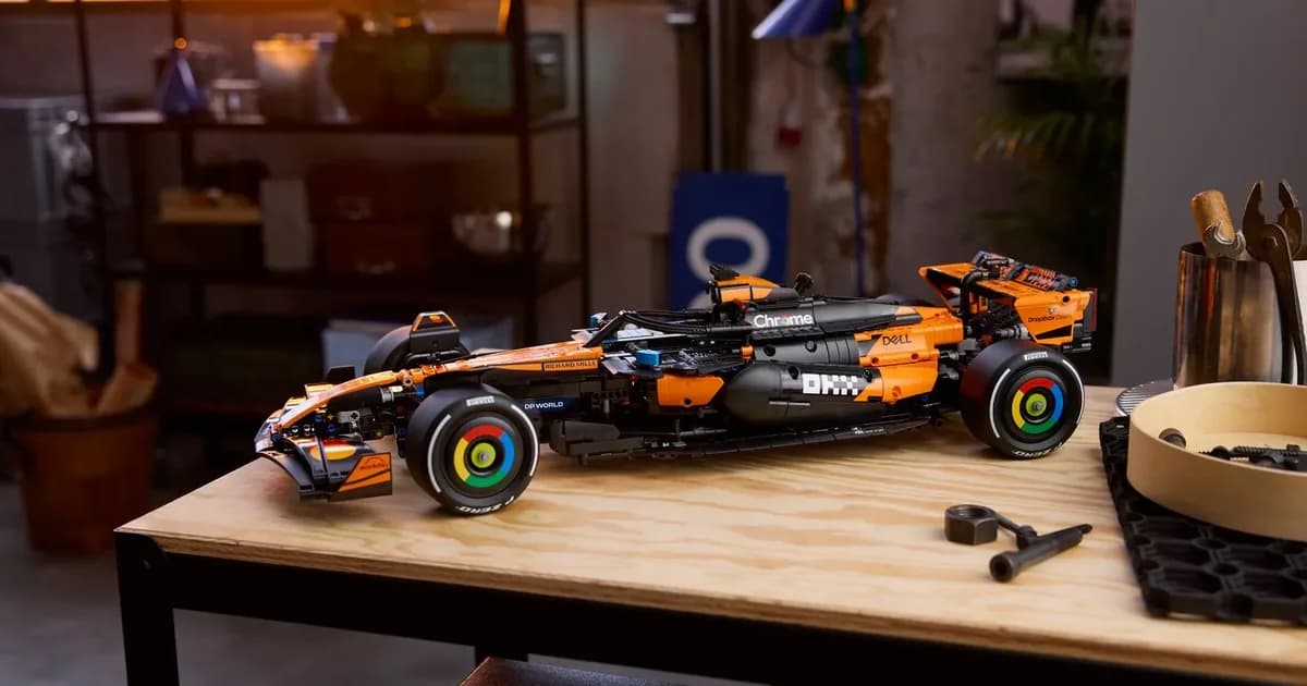 LEGO Technic McLaren MCL39 F1 car 42228 in orange and black on a wooden workbench, shelves behind