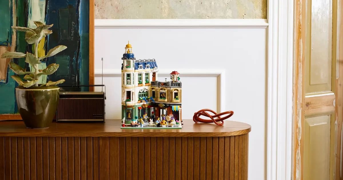 LEGO Icons Shopping Street 11371 modular building on a wooden sideboard beside a potted plant and a radio