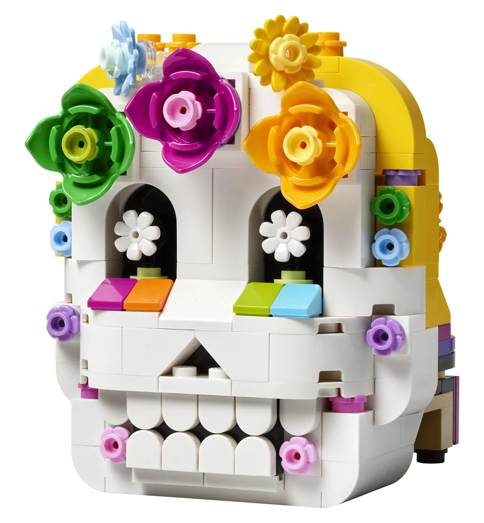 LEGO Altar of the Dead 40811, a white brick-built skull decorated with pink, purple, orange and green flowers, with a yellow arch on one side