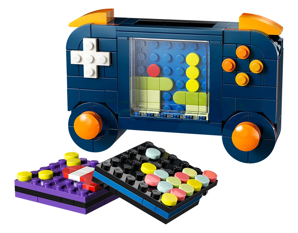 LEGO Creator 3 in 1 Retro Gaming Console 31380, a dark blue handheld console with orange buttons and a brick-built screen, beside two small game cartridges