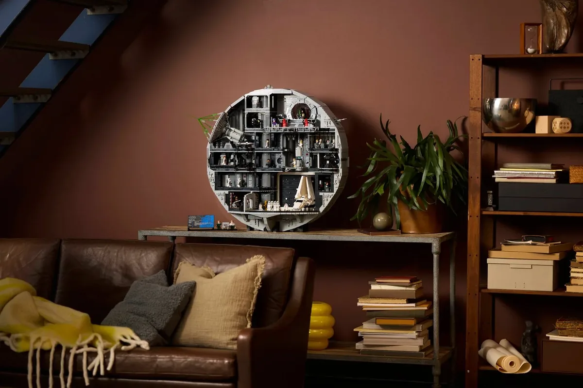 The round grey LEGO Star Wars Death Star 75419, cut open to show its rooms, on a shelf above a leather sofa