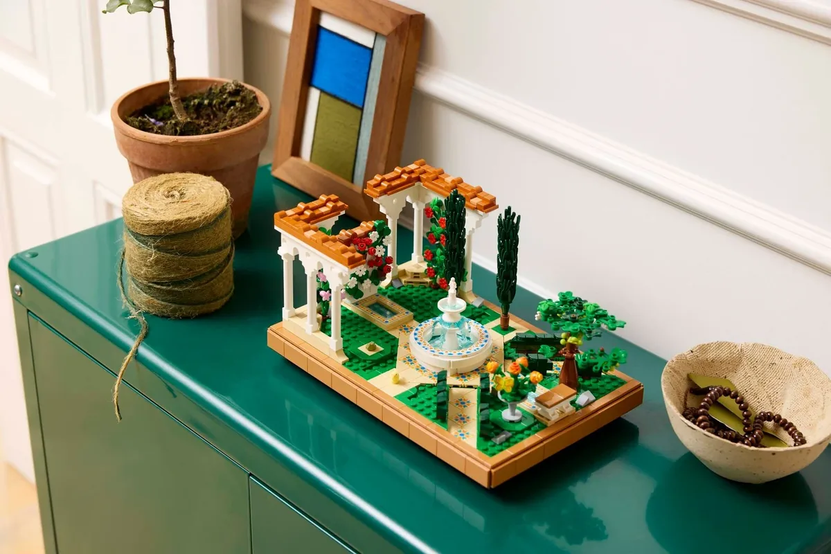 LEGO Icons Fountain Garden 10359: a square garden model with a white fountain, arches and orange flowers on a green cabinet