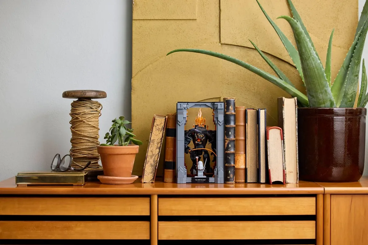 LEGO Lord of the Rings Balrog Book Nook 10367 between books on a wooden sideboard with an aloe plant behind