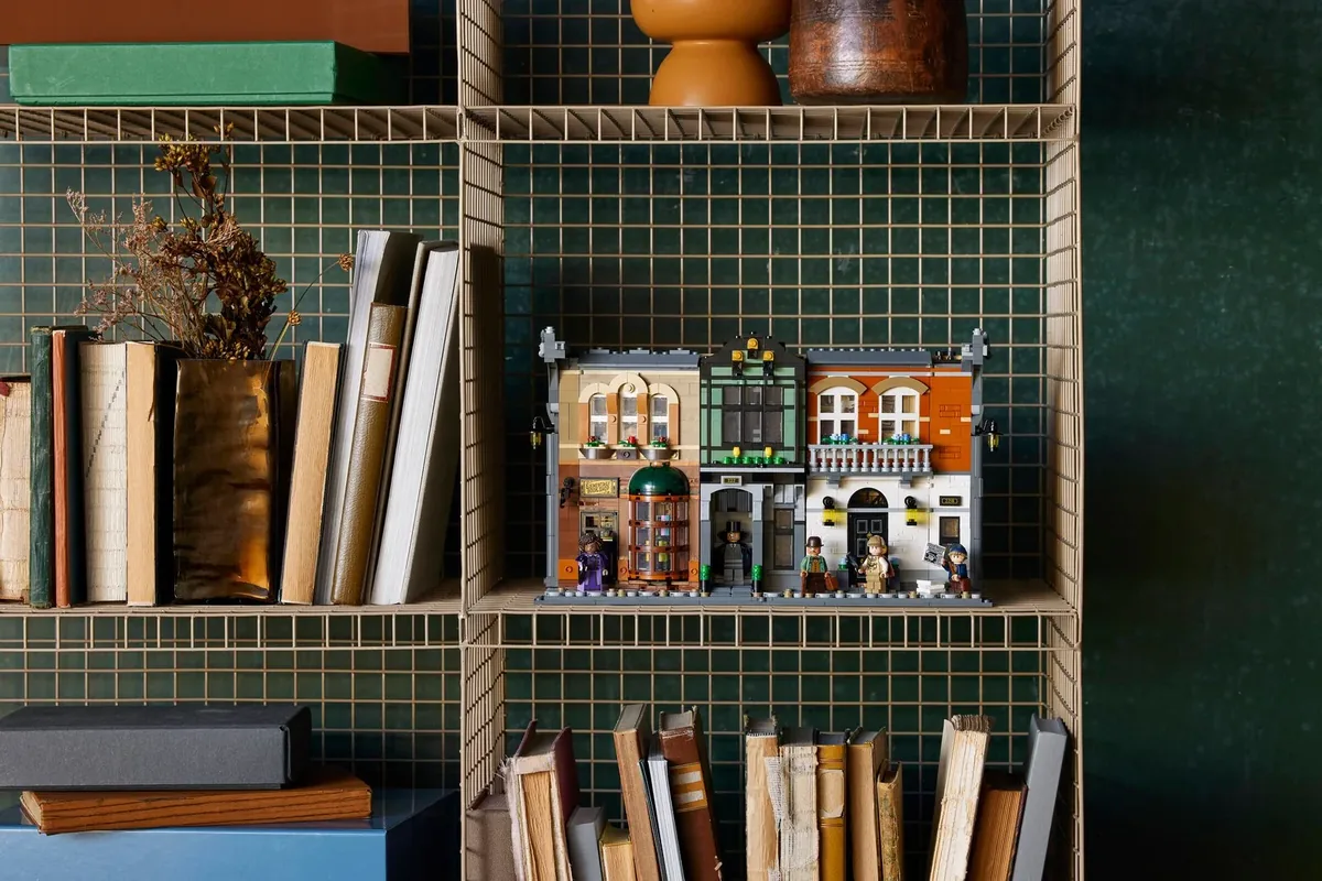 LEGO Icons Sherlock Holmes Book Nook 10351 on a green grid shelf next to books and a dried plant