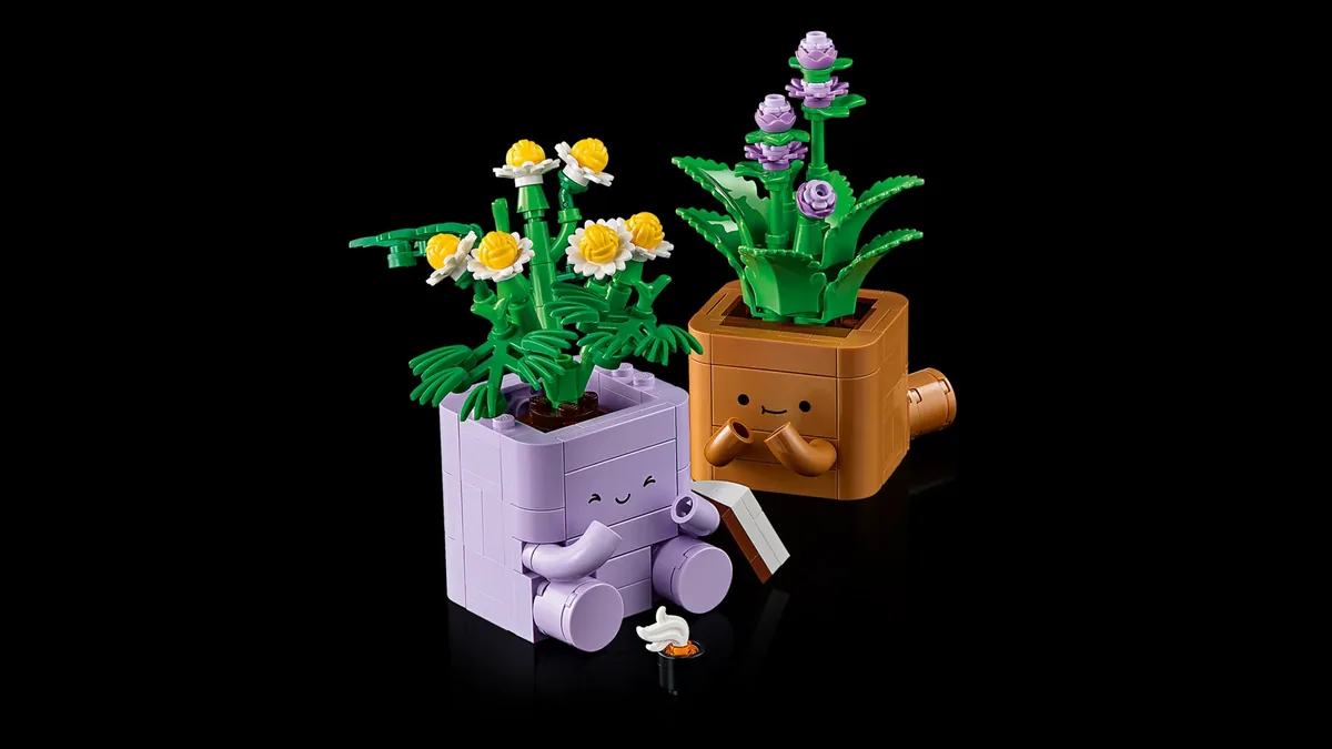 The finished LEGO Cozy Plants on black: a brown pot with a lilac-flowered peppermint and a book, and a purple pot with yellow and white chamomile flowers holding a cup