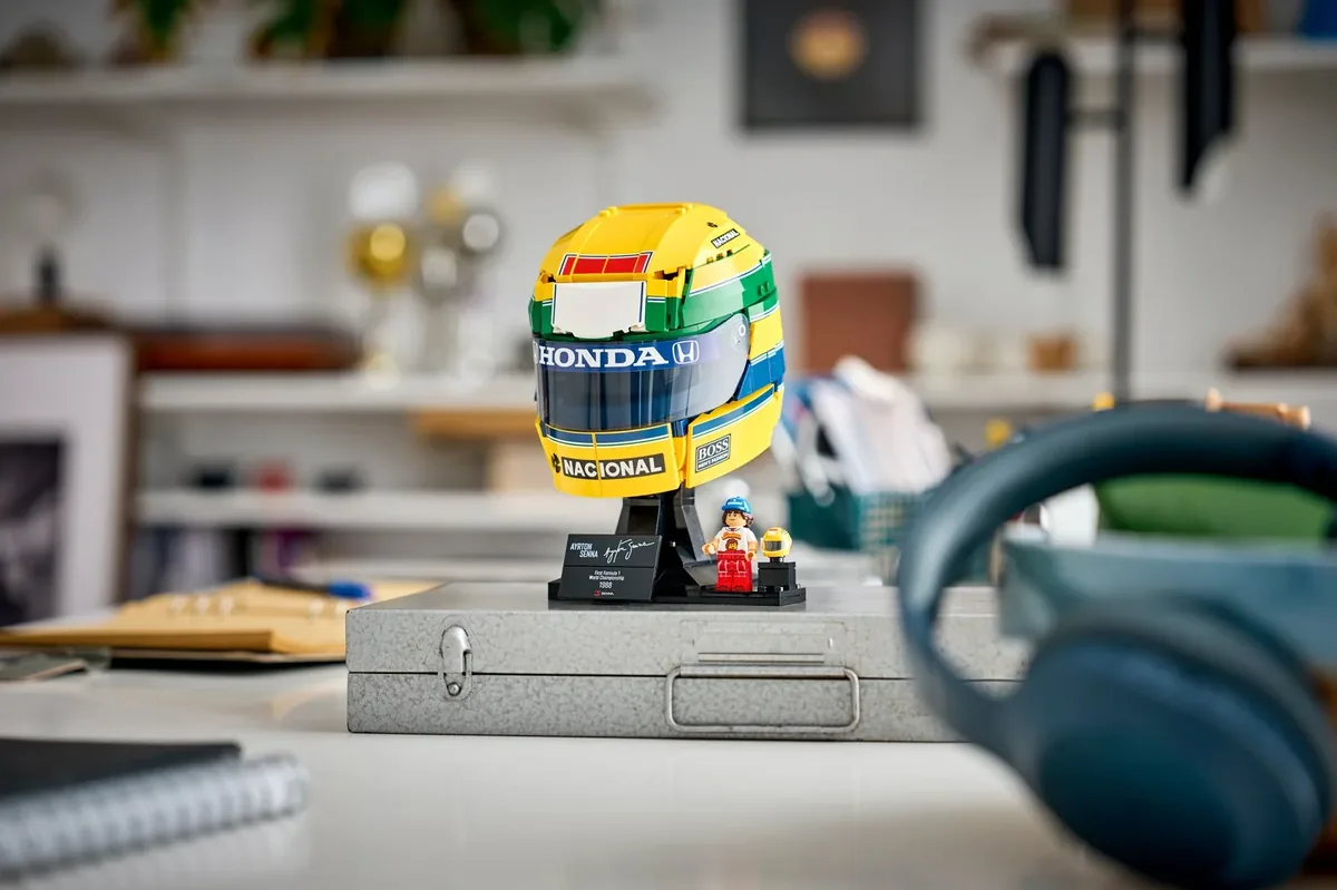 LEGO Editions Ayrton Senna Helmet 43024 in yellow, green and blue on a black stand with a small minifigure