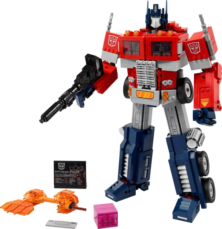The LEGO Icons Optimus Prime 10302 robot standing with its blaster, with the energon cube, Matrix and display plaque in front