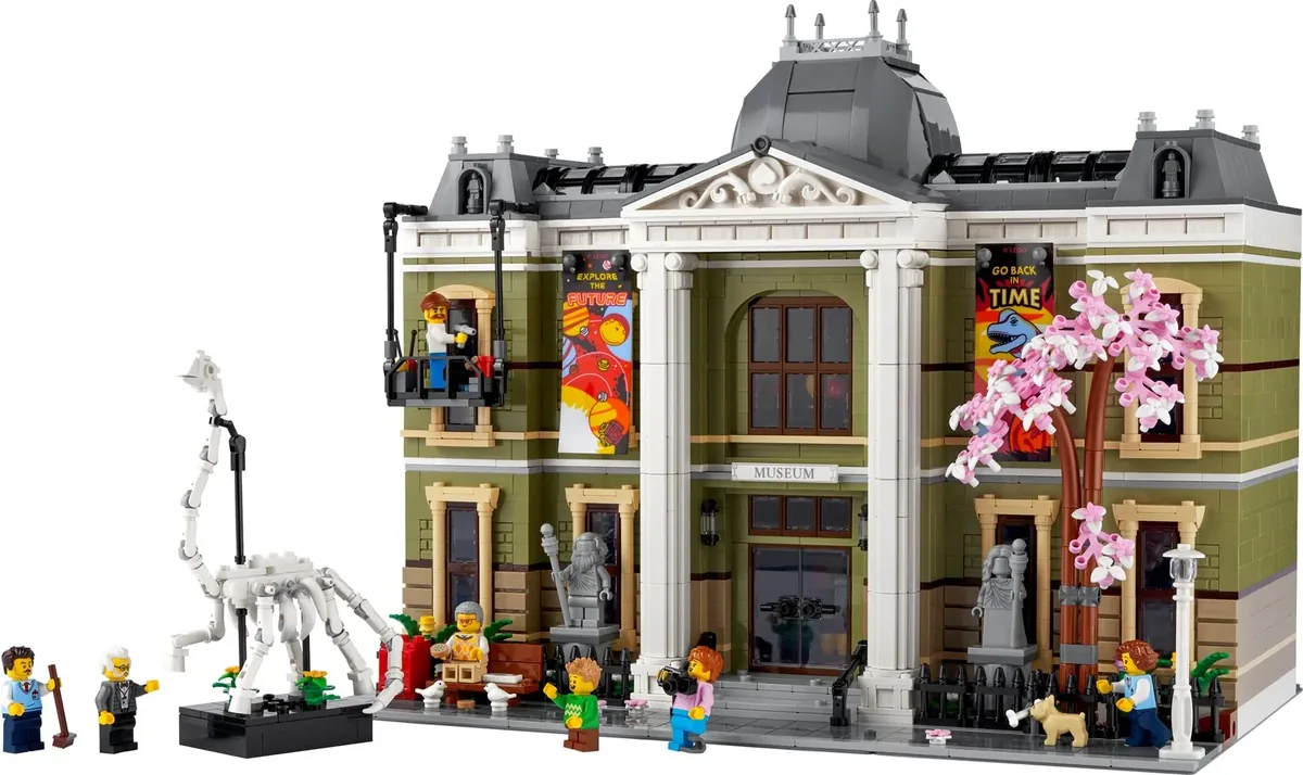 LEGO Icons Natural History Museum 10326 with a dinosaur skeleton, a pink blossom tree and minifigures, on white
