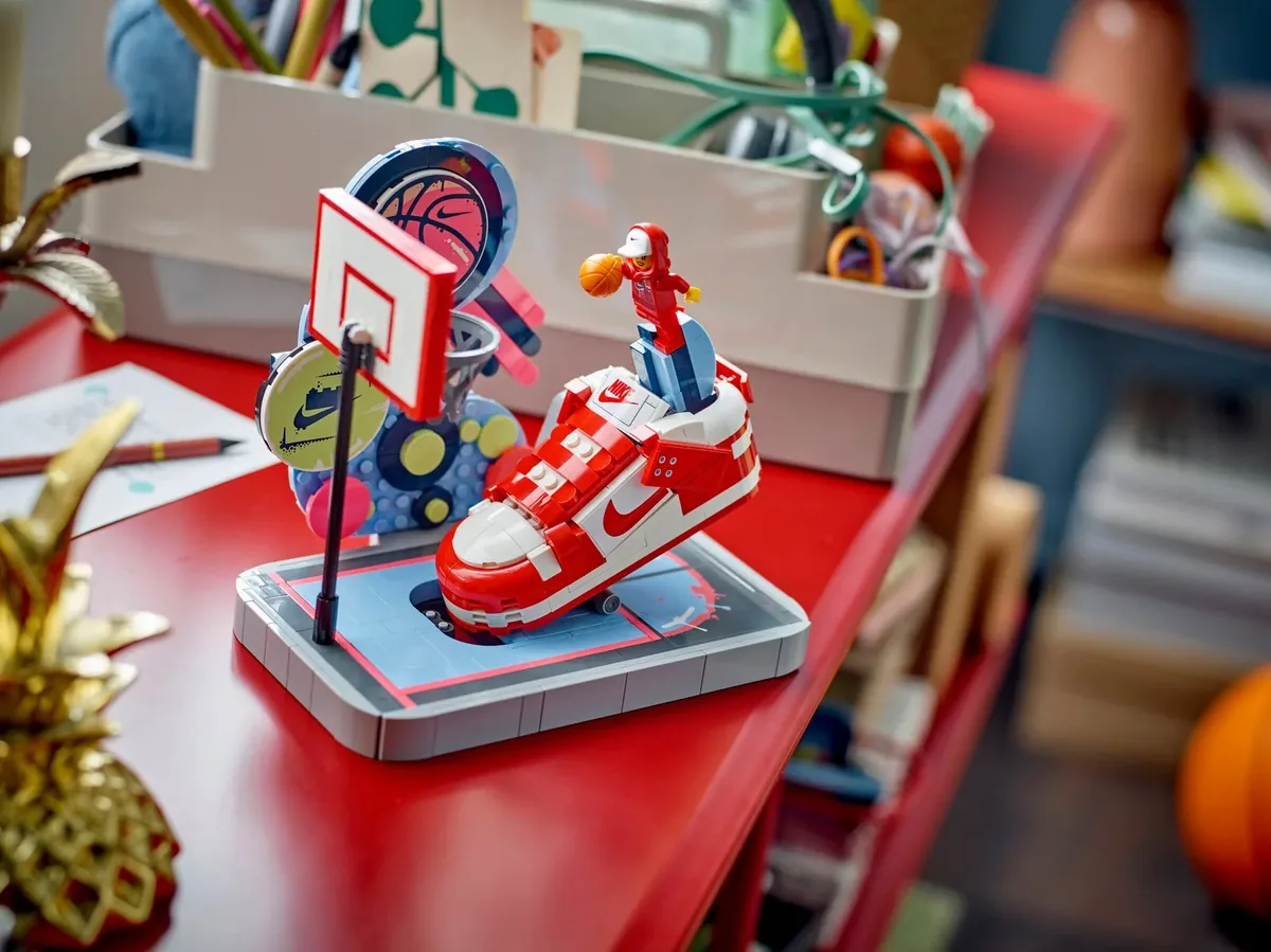 LEGO Nike Dunk Trickshot set with a red and white sneaker, a hoop and a minifigure on a red desk