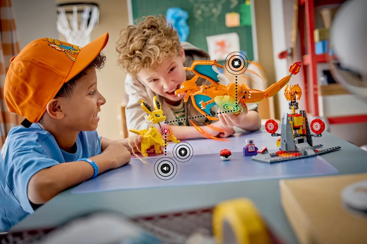 LEGO Pokémon SMART Play Charizard vs. Jolteon Ultimate Battle 72167: two children at a table playing with Charizard and Jolteon builds