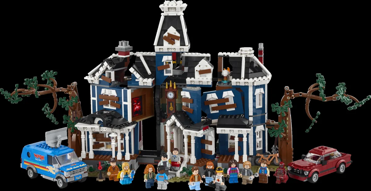 LEGO Stranger Things Creel House 11370: the blue Gothic house with boarded windows, bare trees, the WSQK van and a red car, with 13 minifigures in front