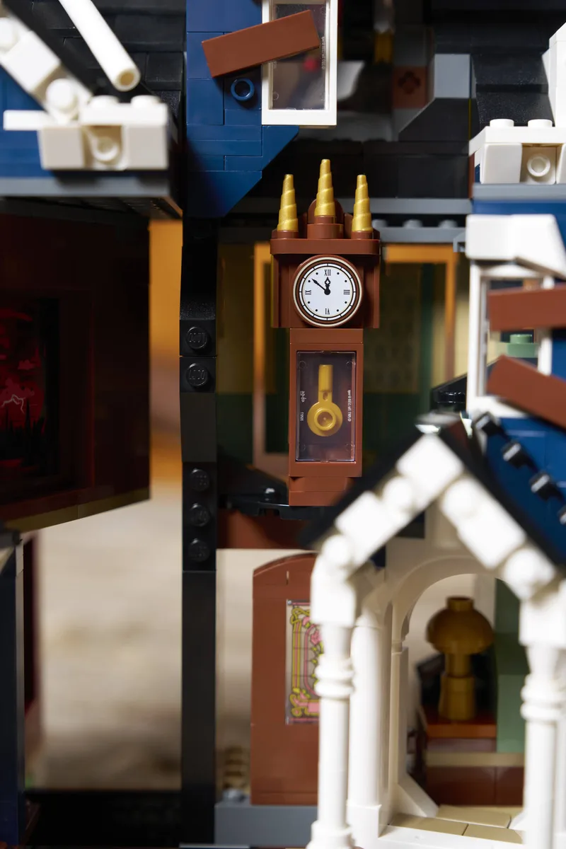 LEGO Creel House 11370 detail: the brown grandfather clock with gold spires inside the house, white porch roof in front