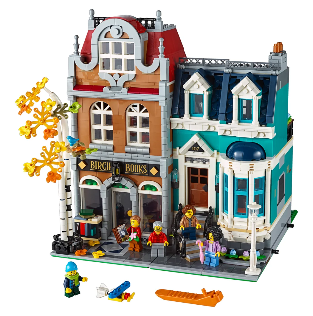 LEGO Bookshop 10270, two narrow townhouses with a bookshop and a tree at street level, a teal house beside it and minifigures in front